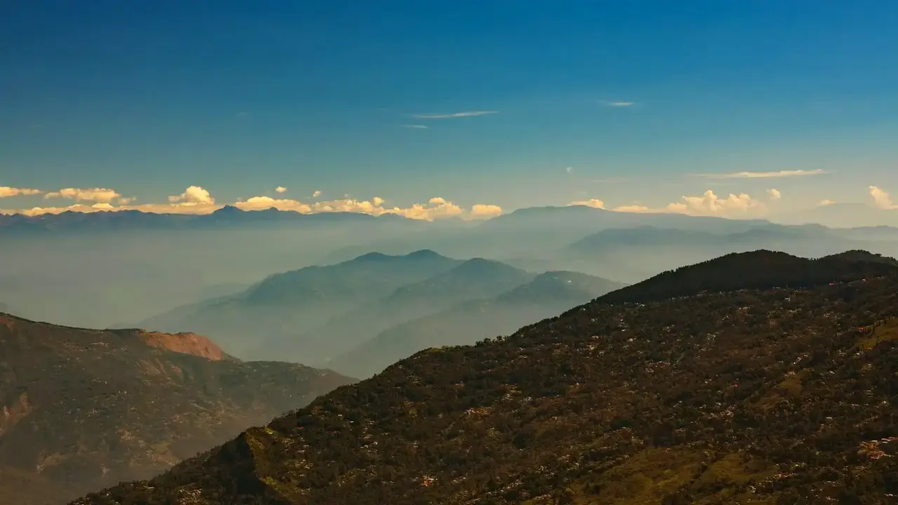 Layered mountain ridges receding beneath a blue sky